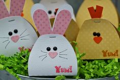 three paper easter bunnies sitting in some grass