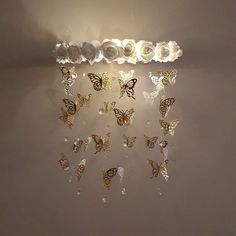 there are many butterflies hanging on the wall and one is white with gold trimmings