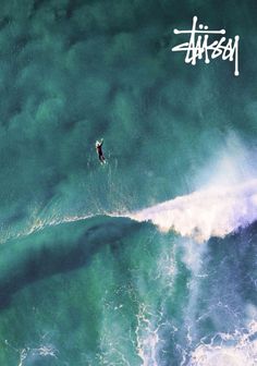 an aerial view of a surfer riding a wave in the ocean with graffiti written on it