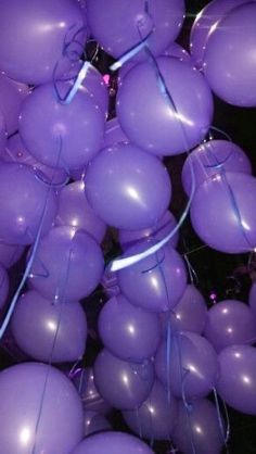 purple balloons are being released into the air