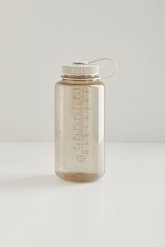 a clear glass jar with a white lid sitting on top of a table next to a wall