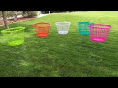 four different colored baskets sitting in the grass