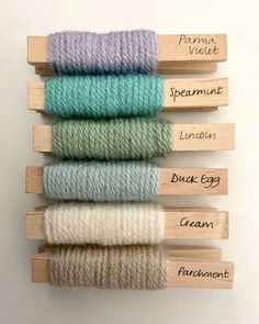 four skeins of yarn in different colors and sizes, with labels on them