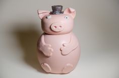 a pink pig with a hat on its head sitting in front of a white background