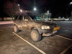 a dirty truck parked in a parking lot at night