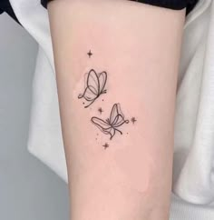 two butterflies tattoo on the left side of the right arm, with stars in the background