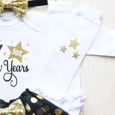 "This is an adorable New Year's outfit. This outfit features a bodysuit with the words \"My First New Years\" The outfit is complete with a matching black head and black/gold tutu. Other options to complete the outfit are a matching black headband/tutu and white leggings with gold stars on them. Other bottoms/headbands are available in the shop as well. HOW TO ORDER: 1.Bodysuit-Select Style and Size from the drop down and add to cart (S/S=Short Sleeve, L/S=Long Sleeve). 2.Add bottom and headband Cute Fitted Party Sets, Cute Party Sets, Fitted Black Sets For Birthday, Black Fitted Sets For Birthday, Cute Fitted Sets For Holiday, Cute Fitted Holiday Sets, Party Outfit Black, New Year's Outfit, Gold Tutu