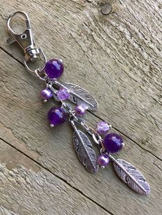 a key chain with purple beads and leaves on it