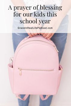 a person holding a pink backpack with the words, a prayer of blessing for our kids this school year