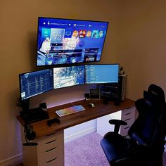 two computer monitors sitting on top of a wooden desk