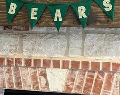 there is a sign that says bears hanging on the wall above a fire place in front of a brick fireplace