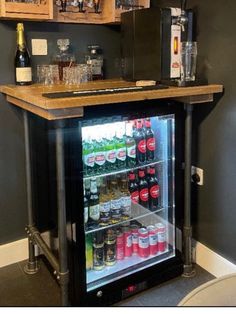 an open refrigerator with drinks in it next to a counter top and shelves on the wall