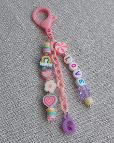 a key chain with charms attached to it on a carpeted floor next to a pair of scissors