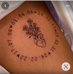 a tattoo on the side of a woman's leg with flowers and numbers in it