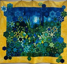 a quilted wall hanging with blue and yellow flowers in the woods on it's side