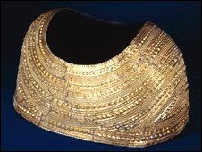 an old gold necklace with beads on it