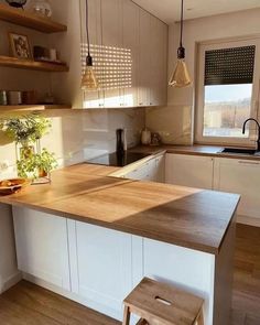 a kitchen with an island and wooden counter tops in the center, along with two stools