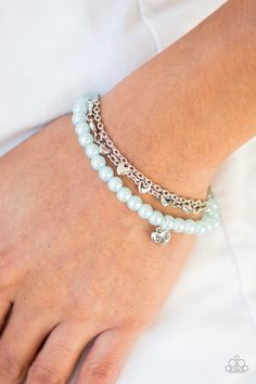 A strand of pearly blue beads, shimmery silver chains, and a row of glistening silver hearts layer around the wrist. A dainty silver heart stamped with the word, "love" swings from the beaded strand for a romantic finish. Features an adjustable clasp closure. Silver Heart Bracelet, Word Love, Heart Stamp, Silver Chains, Paparazzi Accessories, Mean It, Blue Pearl, Paparazzi Jewelry, Bracelet Clasps