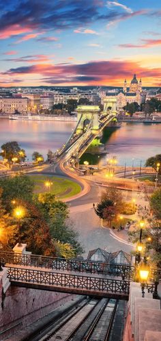 the city is lit up at night by the water