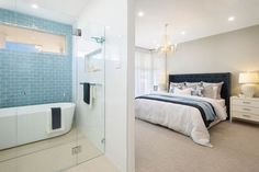 a bedroom with a bed, bathtub and chandelier next to a walk in shower