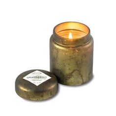 a candle that is sitting next to a container with something on it's side