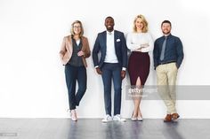 three men and two women standing in front of a white wall with their arms crossed