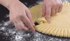 a person is kneading dough into a pie crust