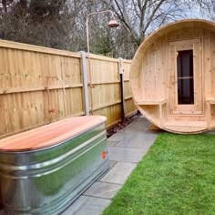 a wooden hot tub sitting in the middle of a yard next to a green lawn