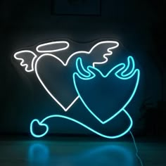 a neon sign that is lit up in the dark with angel wings and heart on it