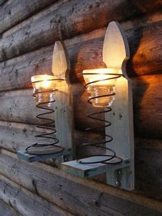 two lights are attached to the side of a log cabin wall mounted on wood planks