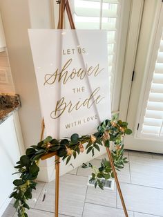 a sign that says let us shower the bride with love and greenery on it