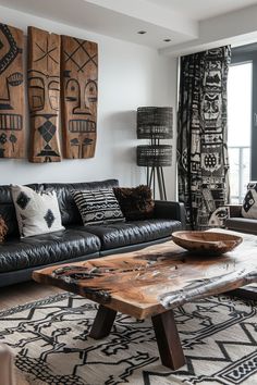 a living room with black leather couches and wooden table in front of large windows