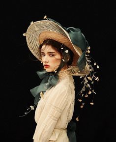 a woman wearing a large hat with flowers on it's brim and neck