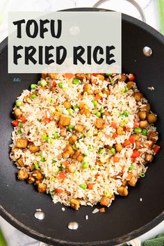 fried rice with peas and carrots in a skillet on a marble counter top