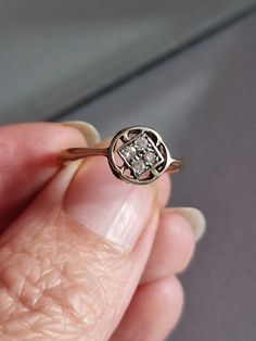 a close up of a person holding a ring with a diamond in it's center