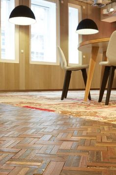 a room with chairs and a rug on the floor