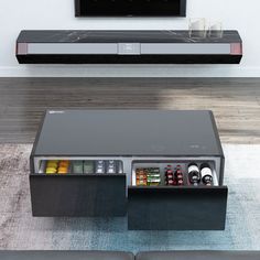 a coffee table with an open drawer in front of it