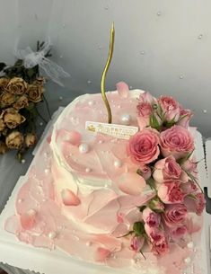 there is a pink cake with flowers on it