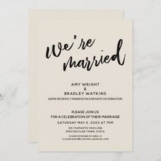 we're married wedding announcement card with black ink on white paper and marble background