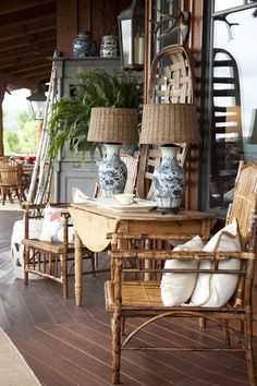 an outdoor patio with wicker furniture and blue and white vases on the table