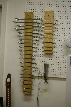 there is a peg board with tools hanging on the wall next to it and an electrical wire