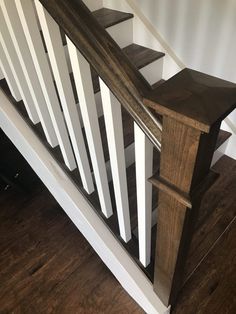 a wooden banister next to a white wall