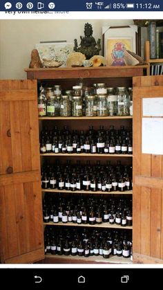 an old wooden cabinet filled with lots of bottles and jars on top of it's shelves