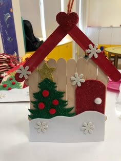 a small house made out of wood and decorated with christmas decorations on the top, sitting on a table