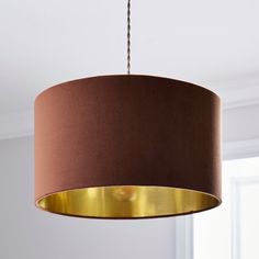 a brown lamp shade hanging from a ceiling