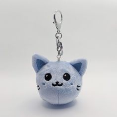 a blue cat keychain with eyes and ears on it's face is shown