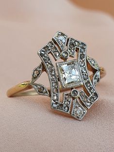 an antique diamond ring on a pink cloth