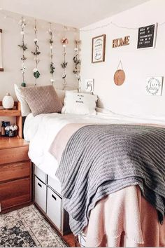 a bedroom with white walls and wooden floors, decorated with garlands on the wall