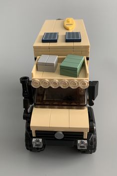 a toy truck with solar panels on the roof is shown in front of a gray background