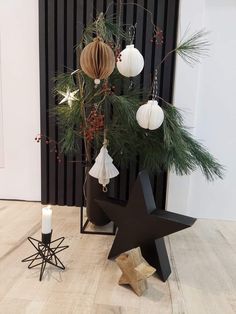 a small christmas tree with ornaments hanging from it's branches and on the ground